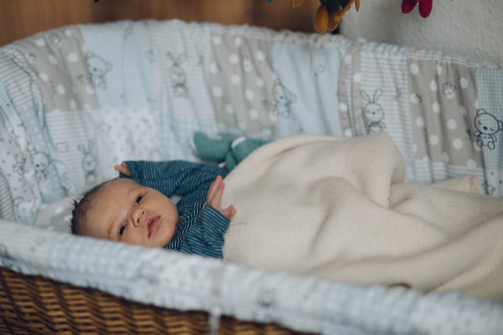 Neugeborenenfotos Berlin-Wedding: Neugeborenes liegt in Stubenwagen bei Familienreportage in Berlin-Wedding