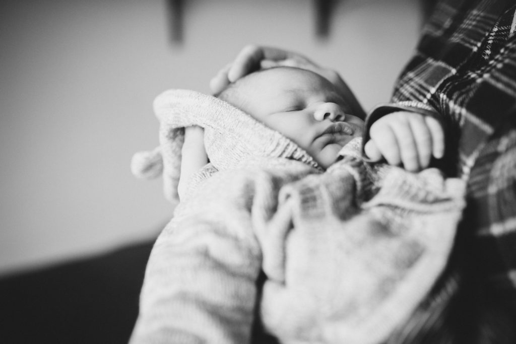 Neugeborenenfotos Berlin Familienreportage Berlin-Wedding: Baby wird im Arm gehalten und gestreichelt