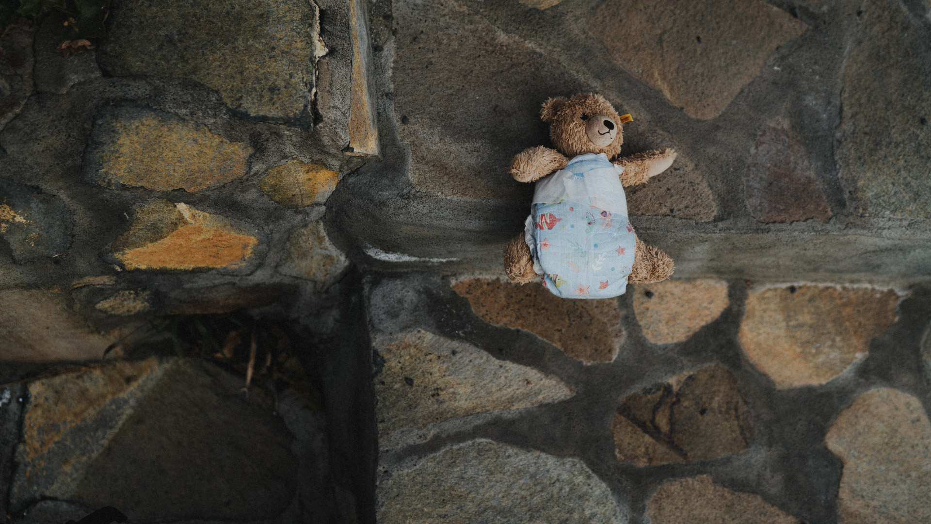 Teddybär liegt auf Boden mit Windel an