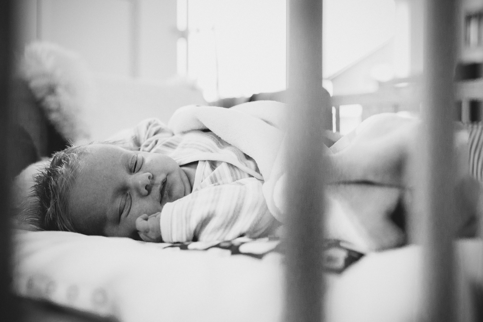 Neugeborenenfotos: Neugeborenes liegt in Babybett bei Familienreportage in Isenbüttel
