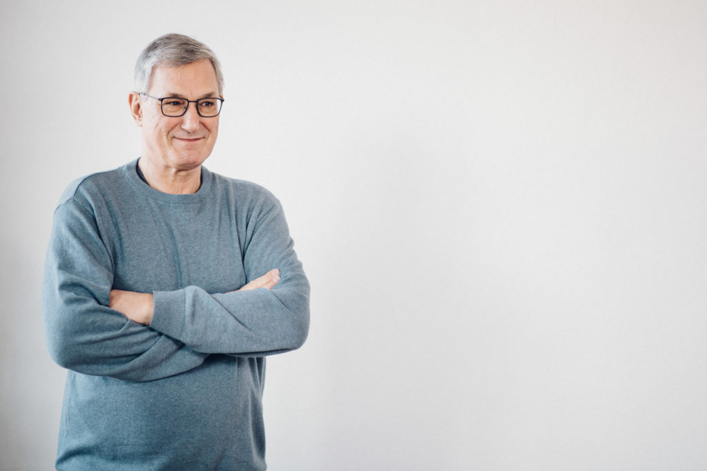 Portraits von Politikern Berlin: Parteivorsitzender Bernd Riexinger mit verschränkten Armen vor grauer Wand