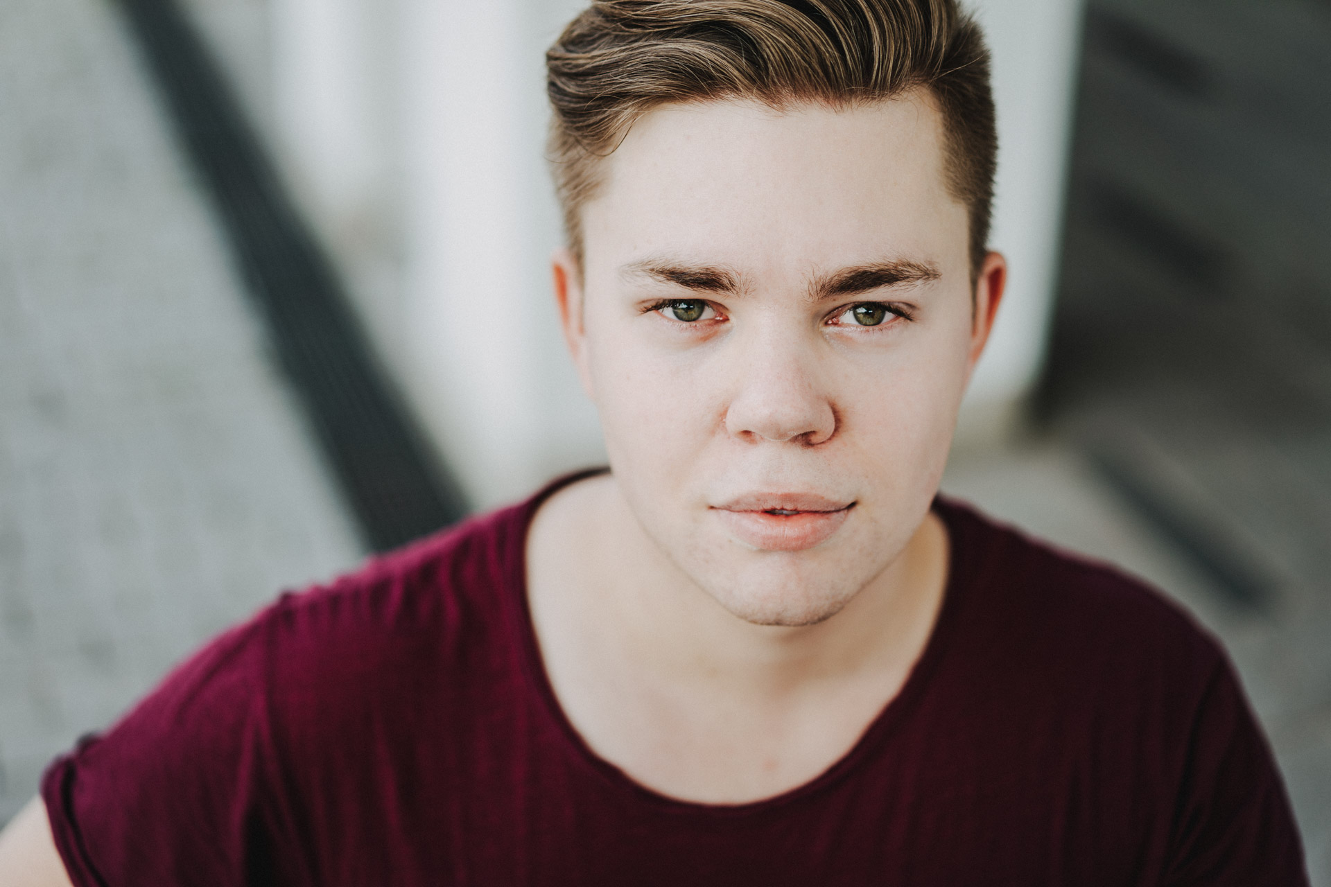 Portraits Berlin: Portraitfoto junger Mann schaut aufmerksam in die Kamera