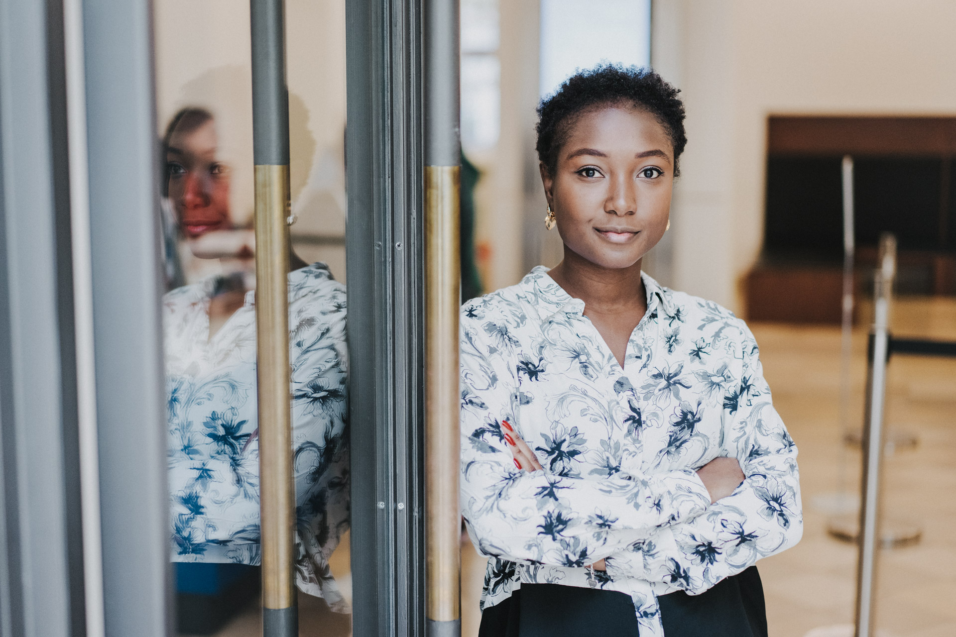Portraits Berlin: Foto Indoor von schwarzer Frau mit verschränkten Armen